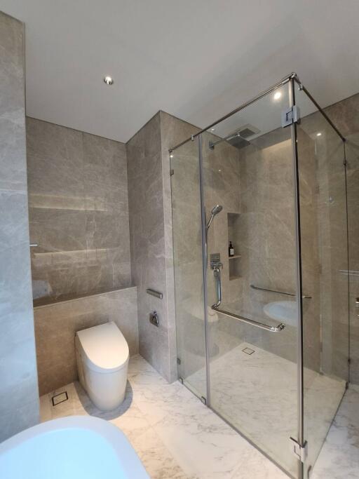 Modern bathroom with glass shower enclosure and marble tiles