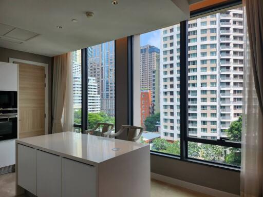 Modern kitchen with large windows overlooking city buildings