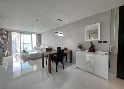 Spacious and well-lit living room with dining area and balcony access