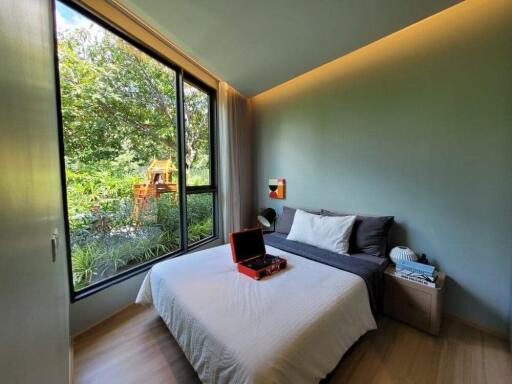 Modern bedroom with large window overlooking greenery