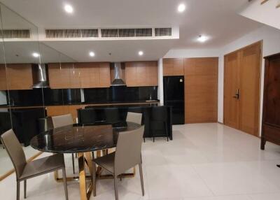 Modern dining area adjacent to kitchen with bright lighting