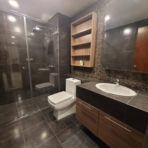 Modern bathroom with glass shower enclosure and wooden vanity