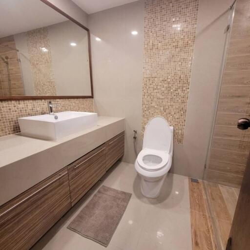 Modern bathroom with beige tiles and contemporary fixtures