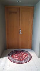 Wooden front door entrance with decorative rug