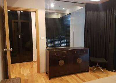 Modern bedroom with wooden flooring and black curtains