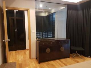 Modern bedroom with wooden flooring and black curtains