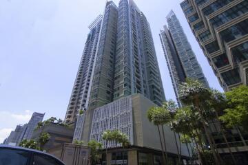 Modern high-rise apartment building exterior under a clear blue sky