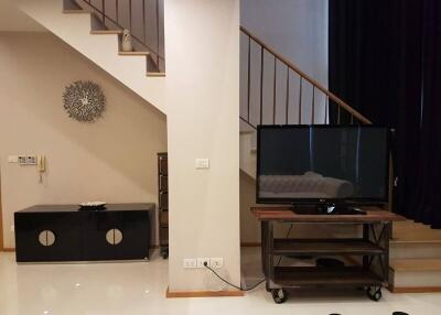 Modern living room interior with staircase and television