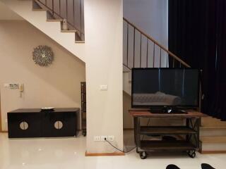 Modern living room interior with staircase and television