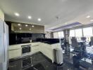 Modern kitchen with integrated appliances and open floor plan leading to a dining area