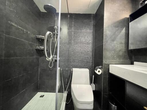 Modern bathroom interior with black tiles and glass shower