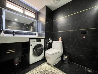 Modern bathroom with black marble walls featuring a washing machine