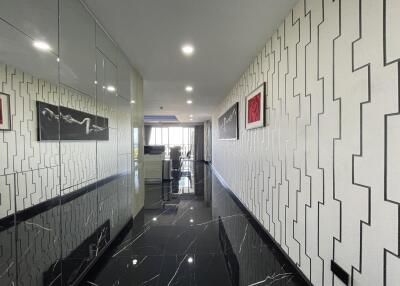 A bright and modern hallway with decorative wall patterns leading to an open living space