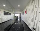 A bright and modern hallway with decorative wall patterns leading to an open living space