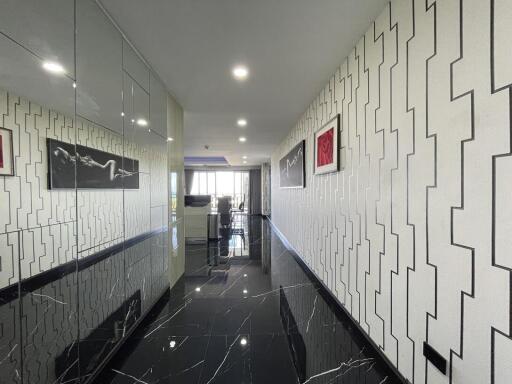 A bright and modern hallway with decorative wall patterns leading to an open living space