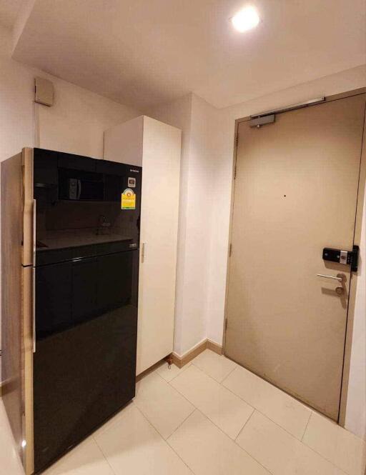 Compact hallway with a refrigerator and an entrance door