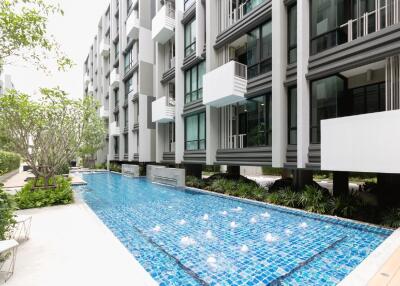 Modern apartment complex with swimming pool and garden area