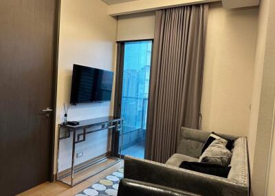 Modern living room interior with comfortable sofa, flat-screen TV, and sliding door leading to balcony