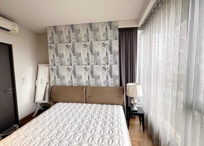 Contemporary bedroom with patterned accent wall and natural light