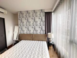 Contemporary bedroom with patterned accent wall and natural light