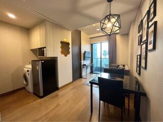 Modern living and dining area with kitchen appliances and balcony access