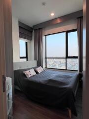 Cozy bedroom with large window and city view