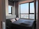 Cozy bedroom with large window and city view