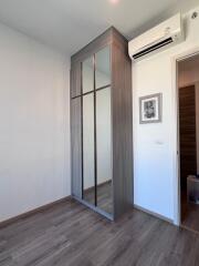 Minimalist bedroom interior with sliding door wardrobe and air conditioner