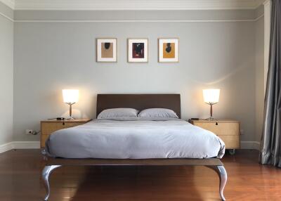 Modern bedroom with a large bed, side tables, and wall art