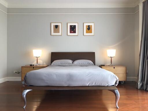 Modern bedroom with a large bed, side tables, and wall art