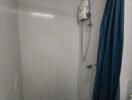 Compact bathroom with electric shower and curtain