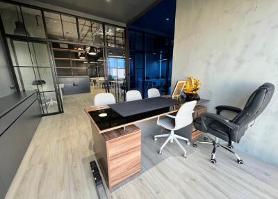 Modern home office with glass walls and wooden furniture