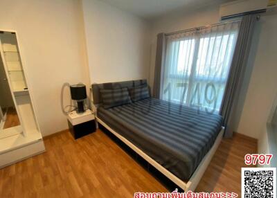 Cozy bedroom with a large bed, wooden floor, and natural light