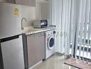 Compact kitchen with modern appliances and washing machine