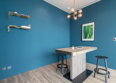 Modern kitchen corner with blue walls, wooden floor, and designer lighting