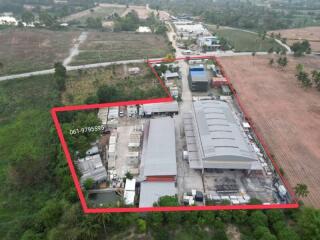 Aerial perspective of the outlined property with buildings and surrounding land