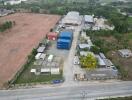 Aerial view of a commercial property with open land, buildings, and containers