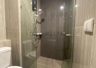 Modern bathroom with glass shower enclosure and neutral tiles