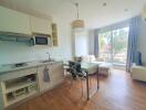 Spacious combined kitchen and living area with modern furnishings and natural light