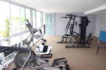Home gym with various exercise equipment and large windows