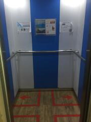 Interior of an elevator with informational posters on the walls