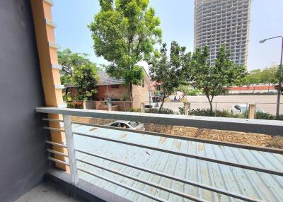 Spacious balcony with a view of surrounding area, including greenery and urban landscape