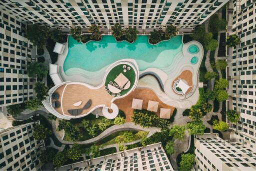 Aerial view of a residential building complex with a large communal swimming pool