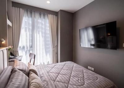 Modern bedroom with a large bed and flat-screen TV