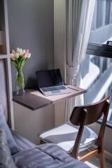 Compact home office space with laptop and chair by the window