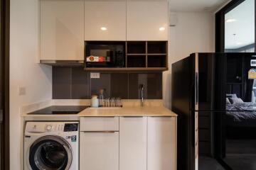 Compact modern kitchen with built-in appliances and wooden accents