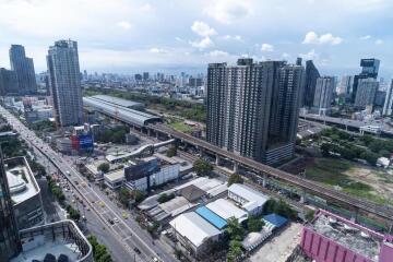 Aerial view of a bustling city with residential buildings, commercial structures, and transport infrastructure