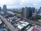 Aerial view of a bustling city with residential buildings, commercial structures, and transport infrastructure