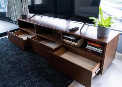 Modern wooden media console with open drawers in a living room