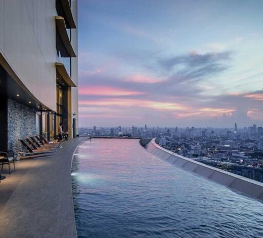 Modern rooftop pool overlooking the city skyline at dusk